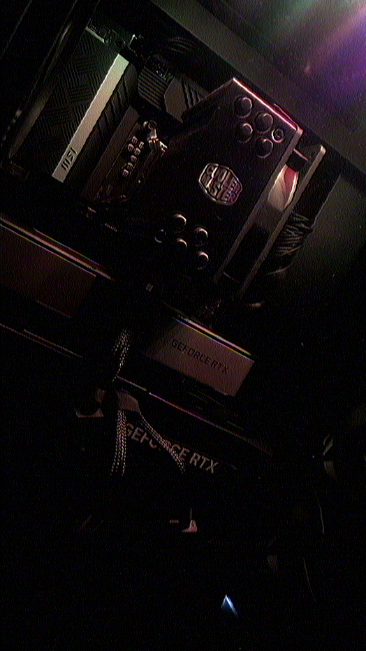 Close up view of a powered desktop interior showing a Cooler Master Hyper 212 (Black Edition) CPU cooler with fan, an MSI PRO Z690-A motherboard, and an NVIDIA GeForce RTX 5070 Ti (SHADOW 3X OC) graphics card with visible GEFORCE RTX text mounted below a GEFORCE RTX 3060 Ti (Founders Edition); braided power cables and nearby components are installed; dim red and purple lighting conveys a focused, technical mood